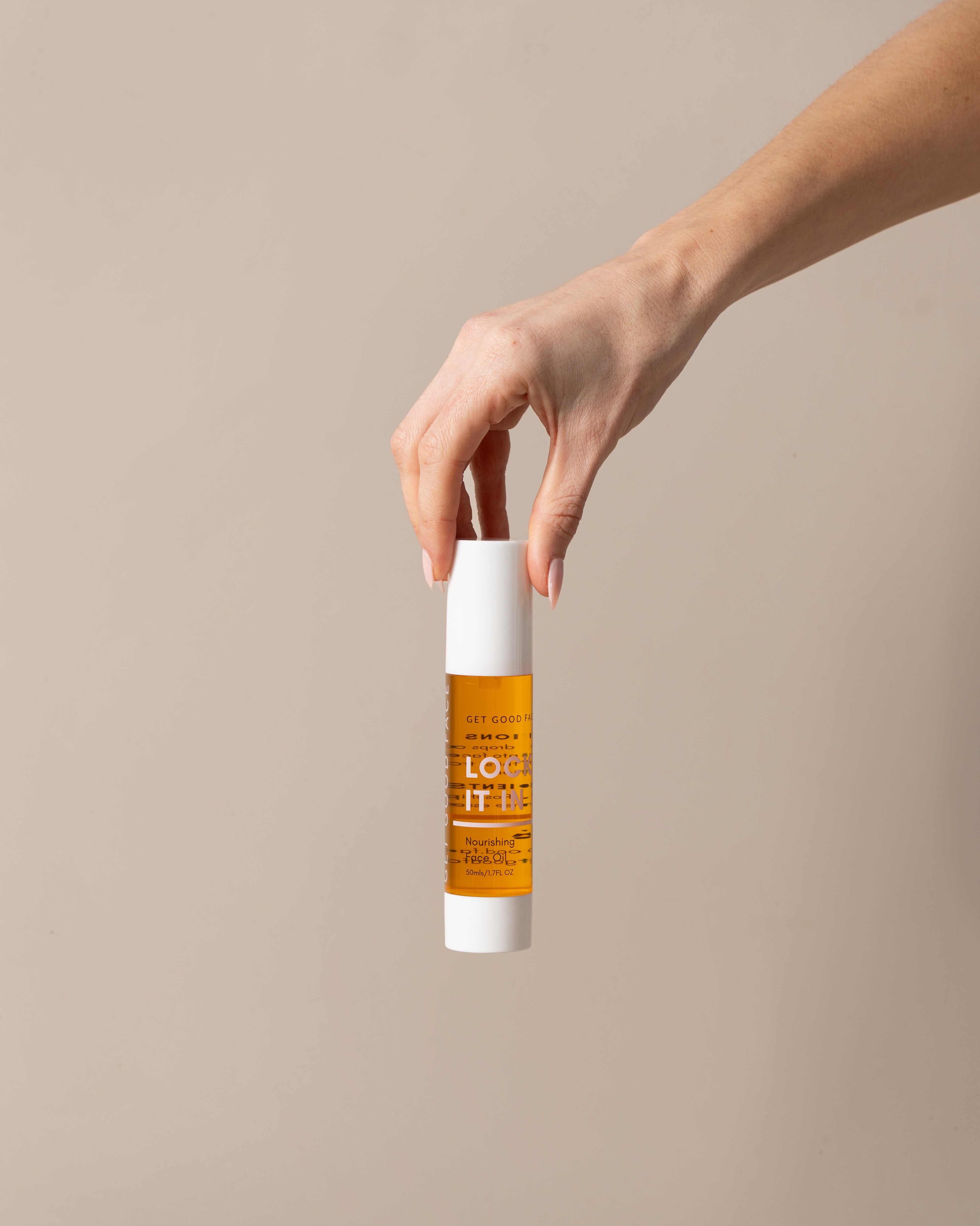 Hand holding a bottle of Lock It In Oil